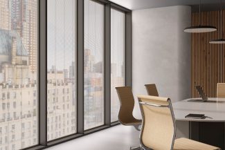 Despacho en gran ciudad con un ventanal de suelo a techo con persianas integradas